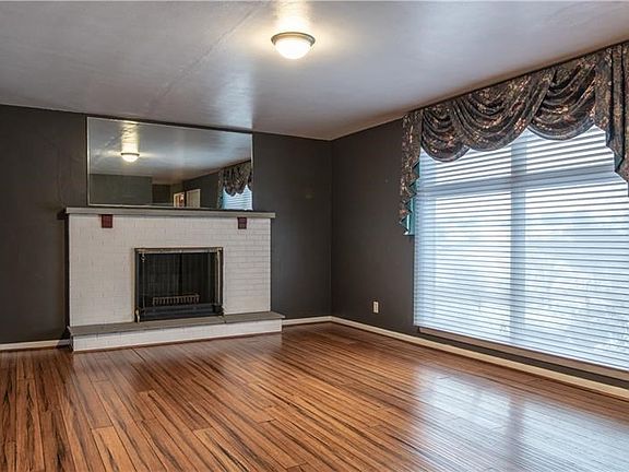 Wood-burning fireplace offers warmth and ambiance to chilly winter days, while also being a focal point to the room.