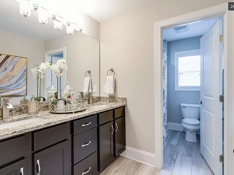 Full en suite master bathroom featuring double basins, shower and tub