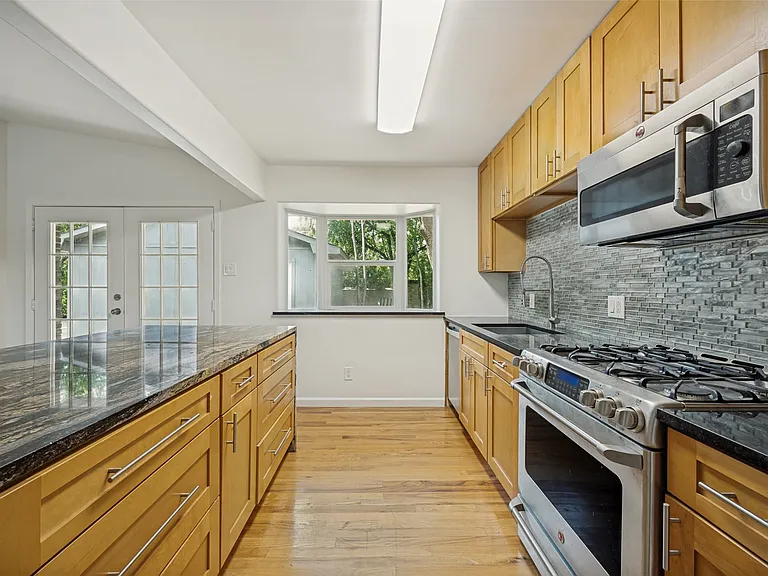 Kitchen featuring wood-finish cabinetry, granite countertops, and stainless steel appliances