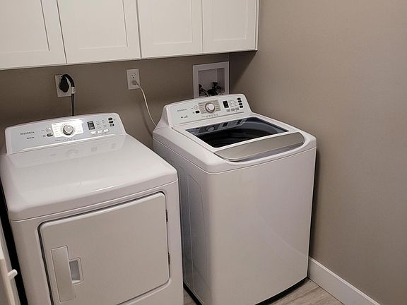 Separate Laundry Room with brand new digital equipment and white cabinetry ...... directly off of eat in kitchen and connects to the Master Bath