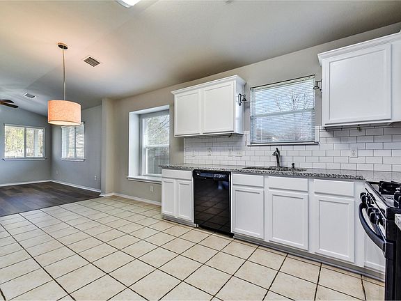 Open, well-lit kitchen with new granite countertops and French-door stainless steel refrigerator