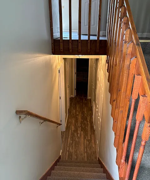 Stairs going downstairs from entrance to both master and guest bedrooms, full bathroom, laundry room and heating unit