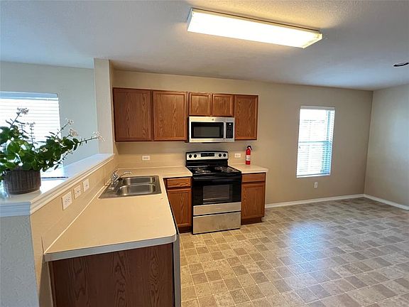 Kitchen featuring sink, stainless steel appliances, and light tile floors