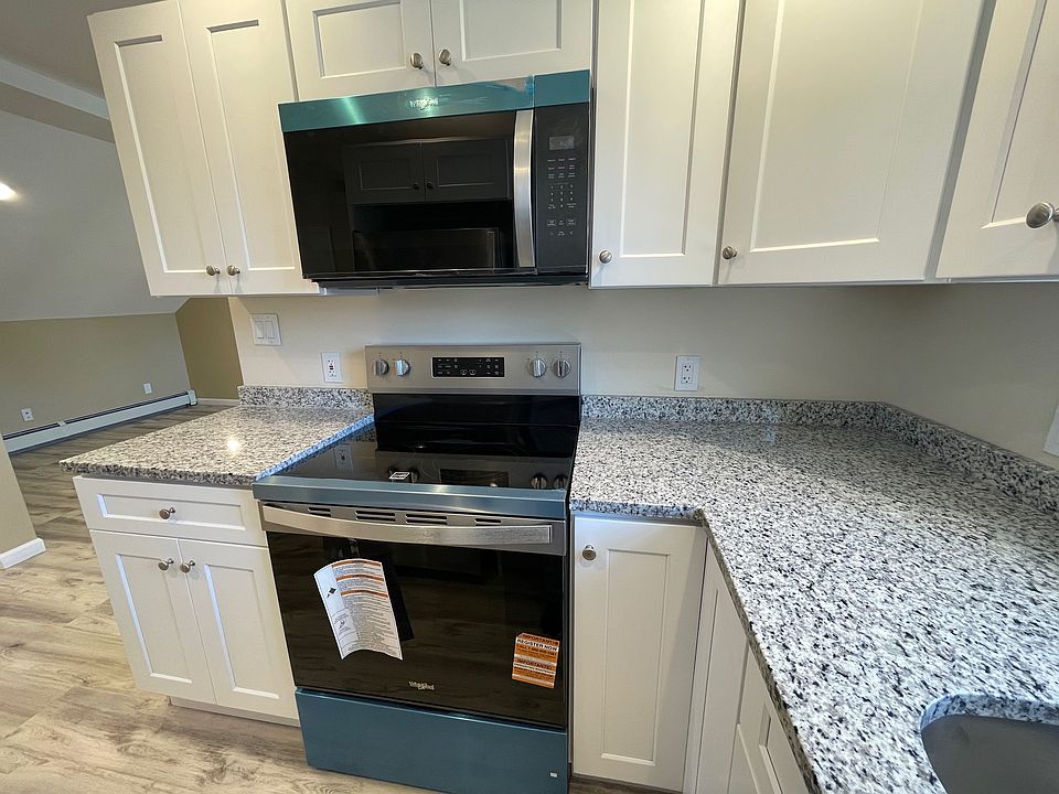 Stunning renovated kitchen with white shaker cabinets, stainless steel appliances, quartz countertops, and a large sunlit window. Flows seamlessly into a spacious dining area_perfect for entertaining!