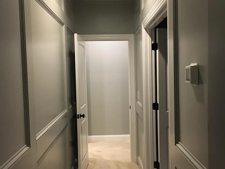 Hall to master bedroom and master bathroom with wood paneling