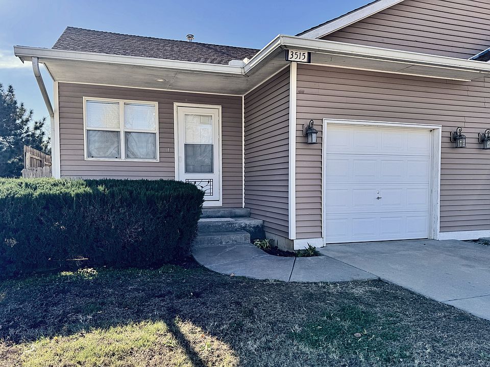 Front of Duplex, showing front door and front porch also, garage entrance.