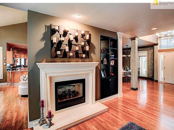 The great room with a see through fireplace and custom built-ins opens up to the hearth kitchen and entry way.