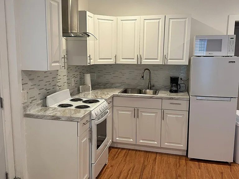 The kitchen is equipped with a refrigerator, coffee maker, and essential amenities.
