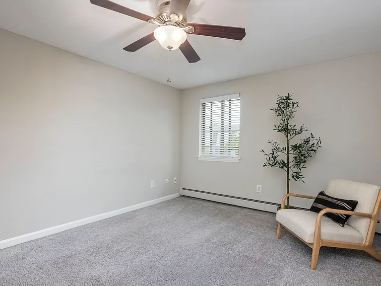 Discover plush bedroom bliss with large windows, plush carpeting, and a ceiling fan for your restful nights.