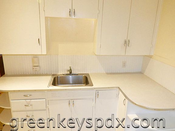 Kitchen has lots of cabinets and drawers