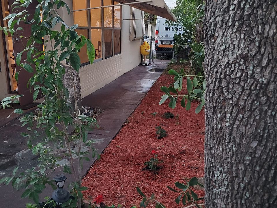 Fenced front yard with gate to the back of the house and parking.