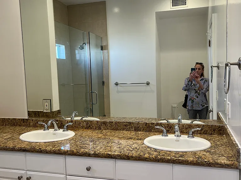 LARGE BATHROOM HAS DOUBLE SINKS WITH TONS OF CABINETS AND LARGE GRANITE COUNTERTOPS