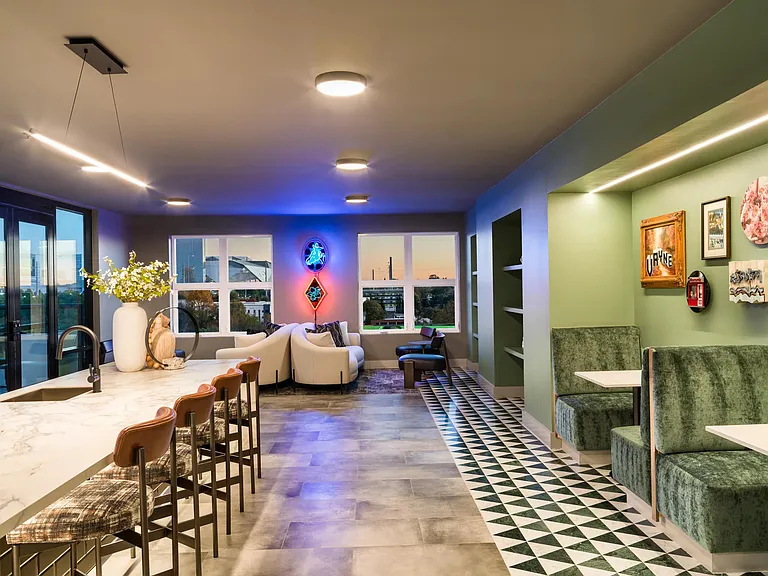 A thoughtfully designed gathering space just off the sky lounge with flexible seating, integrated work areas, and inviting finishes.