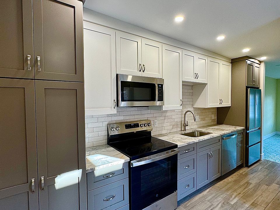 Beautiful galley style kitchen with custom cabinetry with marble countertops