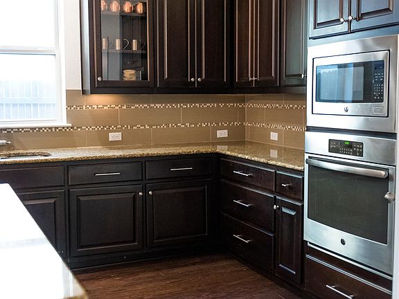 Kitchen featuring granite countertops, large island and stainless steel appliances