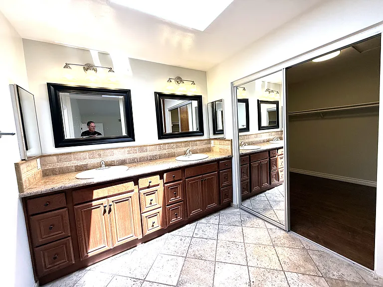 Primary bath viewed with one mirror door open.