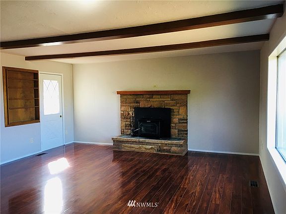 The Living Room is enormous and features brand new floors and a wood-burning fireplace. Door in corner exits to the sundeck and side yard.