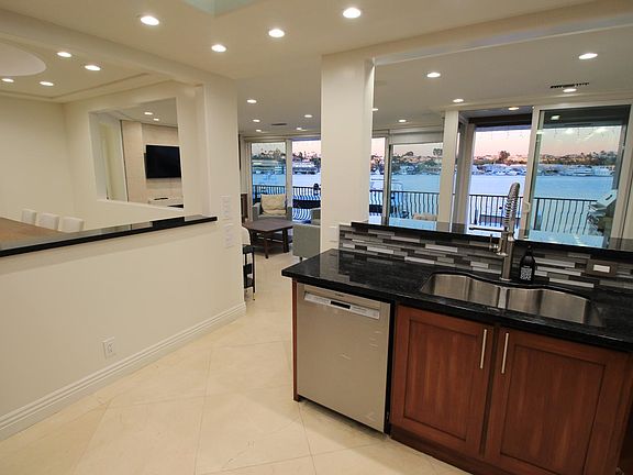 Kitchen looking out to Living Room/left is dining room and view of Newport Harbor will floor to ceiling wall to wall glass to bring outside inside