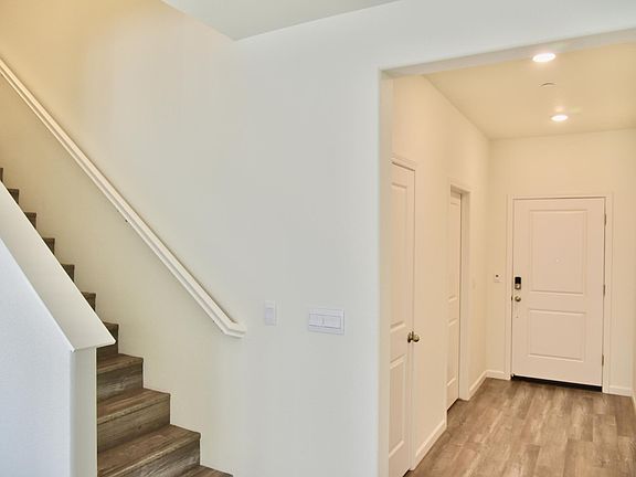 Main hallway with doors for a powder room and coat closet