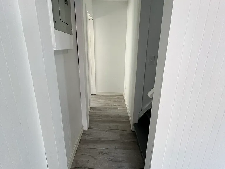 Short hallway to the bathroom and to upstairs