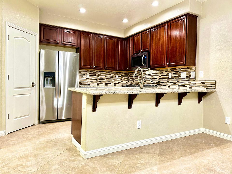 Quartz Kitchen Countertops Beautifully Accented with a Unique Glass Tile Backsplash
