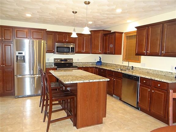 So many cherry tone cupboards and check out the granite counter tops...the island offers that perfect spacefor a snack or extra 