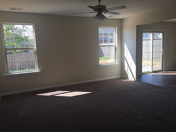 A different view of the living room, looking into the backyard. Blinds have been added to living room and bedroom windows.