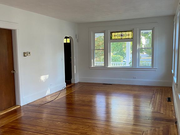 Living room showcasing entry way (which has coat closet with extra storage) and stained glass window