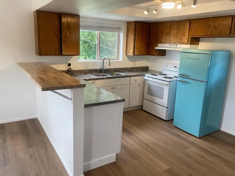 Kitchen with all new countertops, appliances, lower cabinets, lighting and refinished upper cabinets.