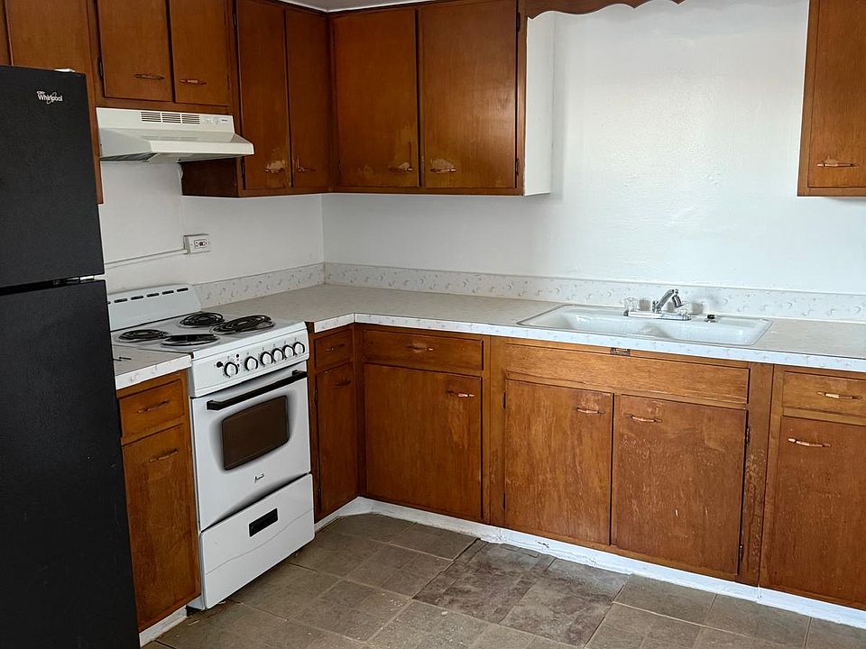 Kitchen comes with range (stove top + oven), hood vent, refrigerator, and sink.