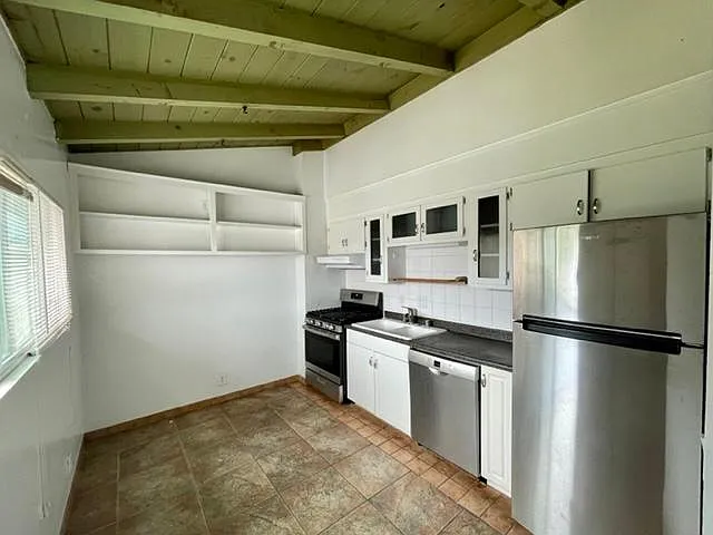 Kitchen with newer appliances including refrigerator, dishwasher and stove with adjacent dining area