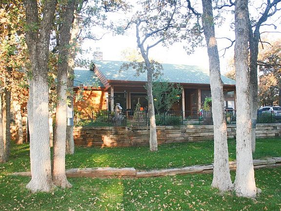 Front of House (view 3) : Shows tiered landscaping and trees on lot.