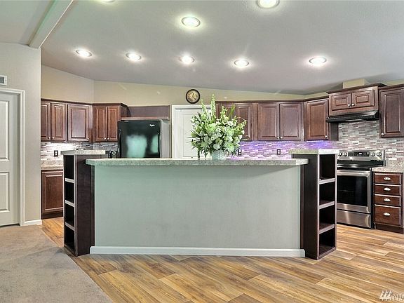 Open kitchen with ample lighting and plenty of prep and storage space. Walk-in pantry, and breakfast bar with built in shelving. 