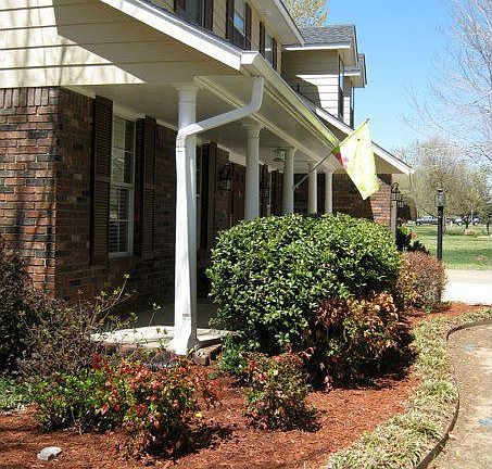 Covered front porch. Gorgeous professional landscaping.