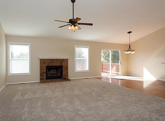Vaulted great room with new carpet and wood burning fireplace