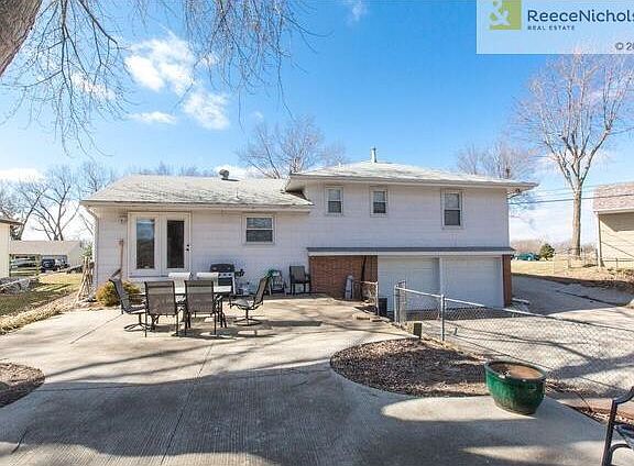 REAR VIEW OF HOME WITH PATIO AND TWO CAR GARAGE
