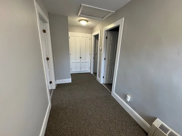 3rd floor hallway with large storage closet and shelving- primary bedroom to left, 2nd and 3rd bedroom to right