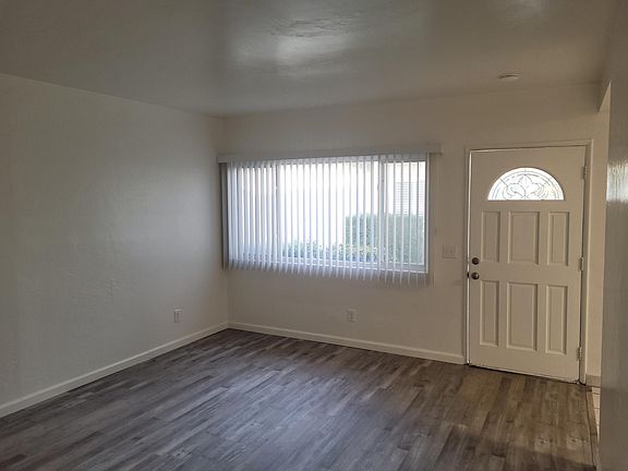 Living room with large window and front door - view from hall.