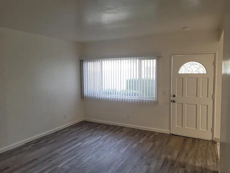 Living room with large window and front door - view from hall.