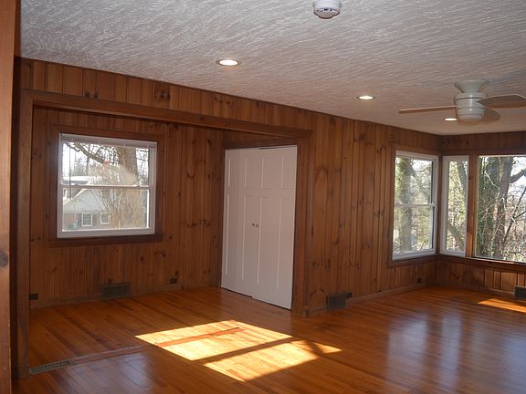 Large upstairs living room with refinished hardwood floors, original wood side paneling, large windows with seasonal mountain views, a fireplace, pantry and dining area.