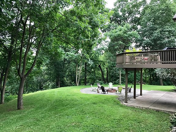 Back yard showing fire pit and upper deck off of the living 