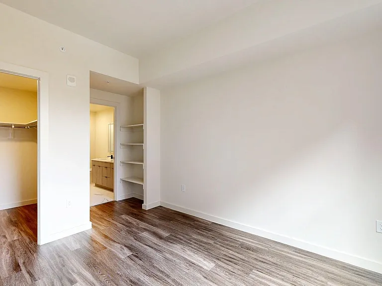Spacious apartment Bedroom with Large Closet, Attached Bathroom and Wood Style Flooring.