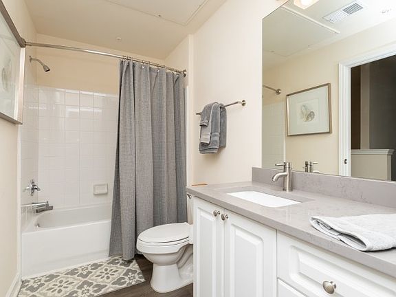 Contemporary bathroom with white vanity and tub-shower combo