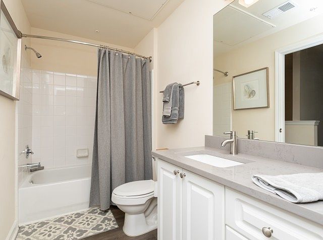 Contemporary bathroom with white vanity and tub-shower combo