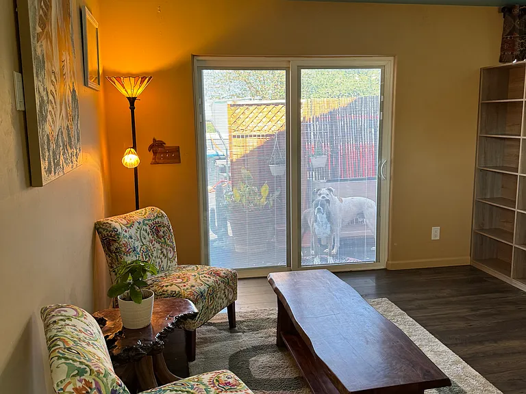 living room area upstairs with built in bookcases that separates the living room from a space used for office or extra guest sleeping area. Stained glass fixtures in every room.