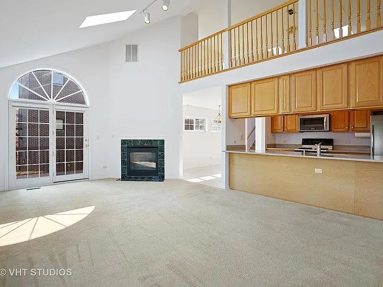 Family room, new hardwood floor replacing the carpet, gas fireplace and outdoor deck though the sliding doors.