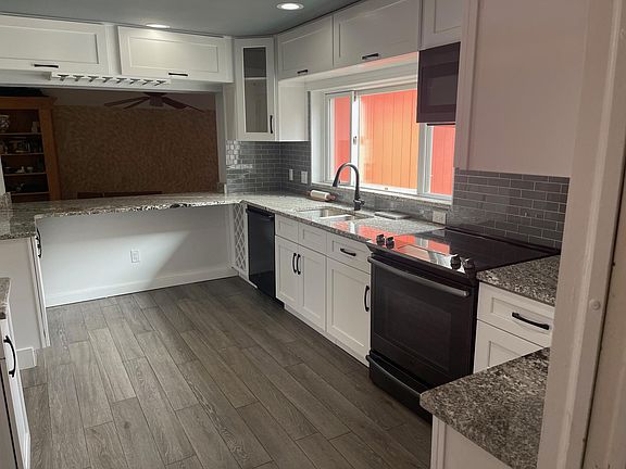 Newly renovavted kitchen, with black stainless steel appliances and a large opening overlooking the family room.