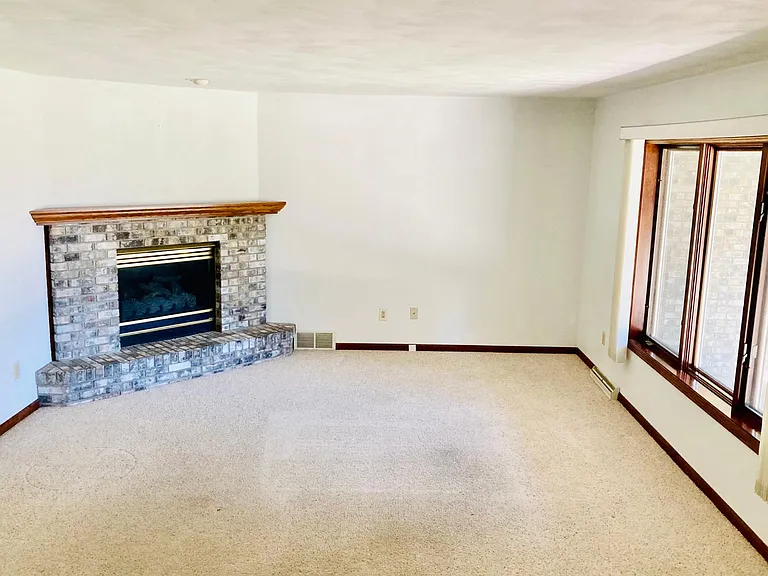 Working and well maintained gas fireplace, and large windows in the living room.