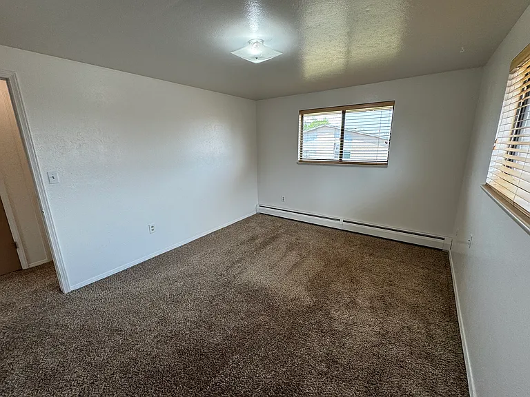 North bedroom with wood blinds, new paint and newer carpet.