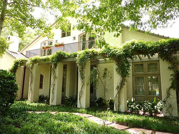 Stucco with Slab Foundation on Builder's Pier with Covered Porches and Flowering Vines.